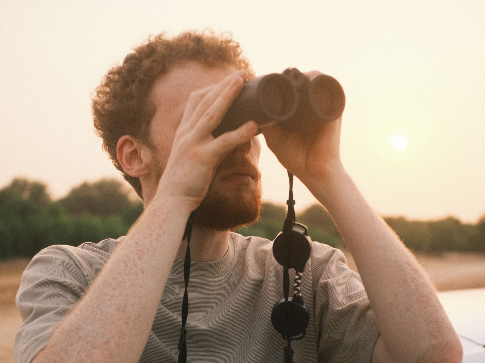 Liam looking through binoculars at sunset